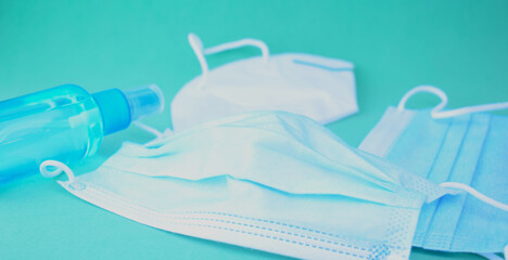 Hygienic and sanitary measures, coronavirus. Surgical mask and hand sanitizer gel on blue background.