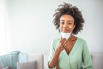 Happy Afro woman portrait - African girl wearing face mask smiling in front of camera - Health care...