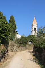 A countryside road leading the the ancient white church on a sunny summer day in Istria, Croatia.