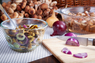 Forest mushrooms honey agarics. Raw wild  mushrooms for cooking. Composition /still-life with wild mushrooms, onions, spices on a wooden background in a rustic style.