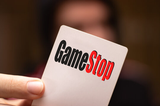 Cambridge UK January 2021 Hand holding a card with the gamestop company logo on it. Game stop shares have been growing extremely as reddit users attack hedge funds and wall street