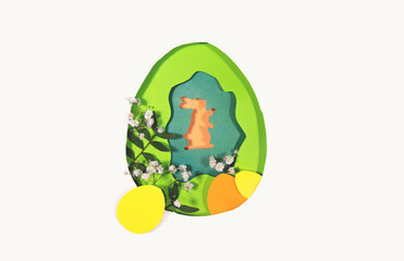 Design for the holiday Happy Easter. Paper art. Egg and rabbit shape cut from paper. Framed with natural plants. For your Easter background. Copy space and flat lay style