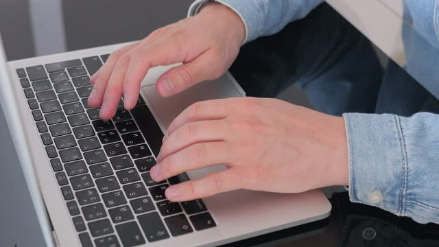 Male hands of business man worker using typing on laptop notebook keyboard sit at home office desk working online, close up side view