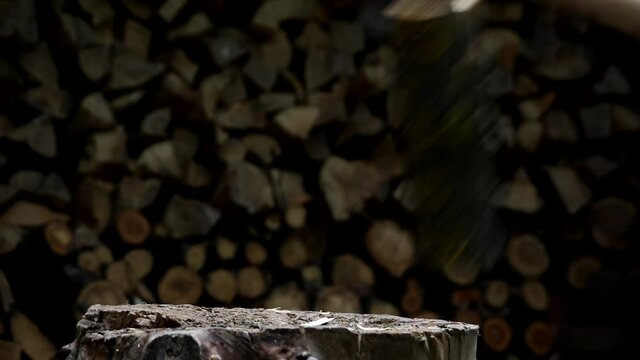 Splitting firewood with an axe. Cutting logs, harvesting firewood for the winter