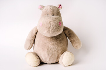 Plush stuffed toy hippo sits on a white background