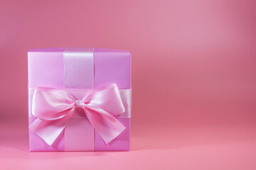 Gift box with a bow on a pink background