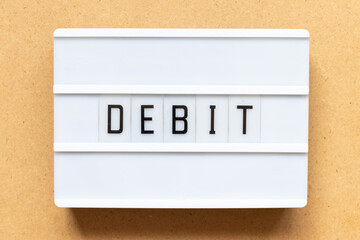 Lightbox with word debit on wood background