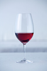 Ein Glas Rotwein auf einem weiß gedeckten  Tisch