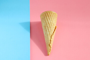 Ice cream cone with abstract blue and pink background. Food concept. Minimalism, mockup, and copy space.