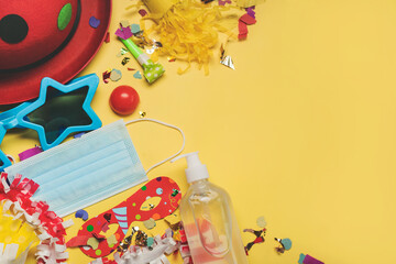Concept of carnival during covid-19.Protective surgical mask,carnival mask and sanitizer bottle