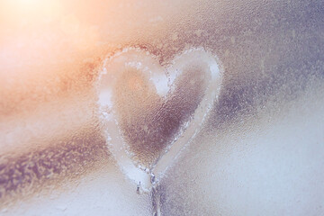 Fototapeta premium Heart on misted glass. Heart on a window background. Heart symbol of love drawn on the glass.