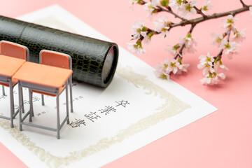 卒業証書と丸筒と学校机