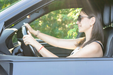 beautiful woman driving and smiling. portrait of happy girl in the car. traveling. enjoying the life