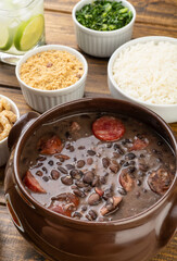 Traditional brazilian feijoada with rice, kale, manioc flour and caipirinha