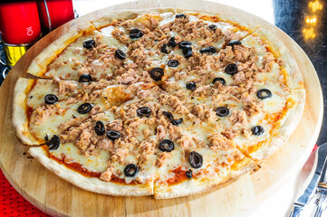 Italian pizza with various type of meat and black olives