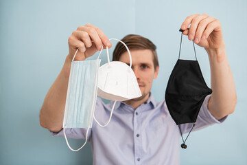 Man holding FFP2, surgical face mask, respirator and cloth masks. Time to upgrade masks as...