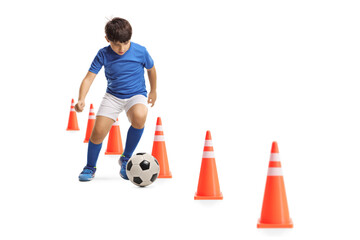 Boy training soccer with obstacle cones
