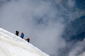 alpinists climbing an alpine ridge in extreme conditions.