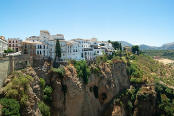 Fototapeta na wymiar Ronda city Spain. Dramatic view of the El Tajo gorge with handsome town houses on the cliff tops. Historic Spanish city. Beautiful panorama.