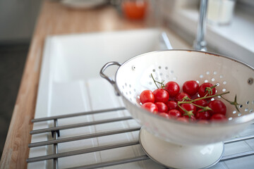 Sweet and fresh cherry tomatoes for a salad in a colander. Vegetables, kitchen, home