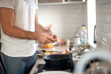 A young guy making a meal. Kitchen, food, home, cooking