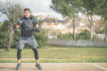 athletic man doing squat and back exercise and cross training with dumbbells