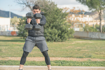 Fototapeta premium athletic man doing squat and back exercise and cross training with dumbbells