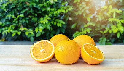 Close-up of front orange fruit on the table with green background at sunrise, selective focus on fresh front orange with drop water on surface oranges. Healthy drink concept