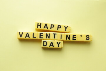 Happy Valentine's Day. An inscription made from yellow cubes. Creative concept.