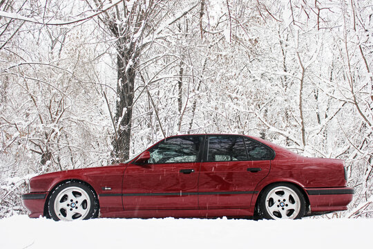 Chernigov, Ukraine - December 21, 2017: Red BMW car on the background of the winter park. Snowy winter and red car. Wonderful winter.