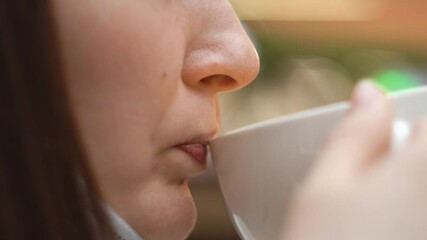 close-up woman in mask, side view, brings cup to mouth, takes off mask, takes sip drink, tea, coffee, licks lips, puts on mask back, precautions, prevention, safety measures, health, pandemic covid 19