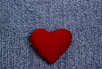 Textile background. red heart on the soft knitted blanket. Valentines day concept