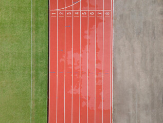 Aerial Top-down view of National Sports Center, Top view of red running tracks, and green grass lawn. Infrastructure for sports activities, running track, shot with a drone looking down