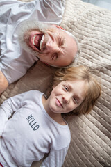 Fototapeta premium Man staying in a bed with his grandson