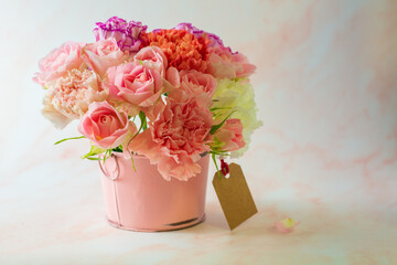 Mather's day concept. Colorful carnation and pink rose in a pink bucket