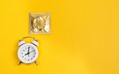 condom alarm clock. time to protect yourself. Safe sex and reproductive health concept
