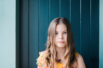 Young girl standing outside in front of a blue door