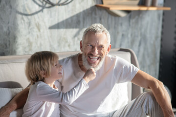 Cheerful child and gray-haired bearded man