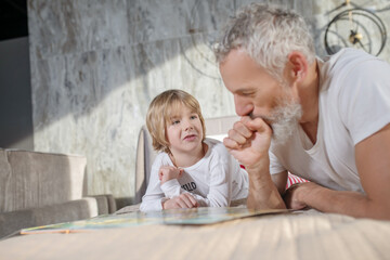 Dad and child at home talking on bed
