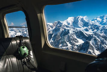 Empty seat with headphone in an airplane with mountains out the window