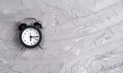 alarm clock on a gray concrete background. copy space. flat lay