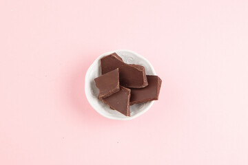 Chocolate bars in plate top view shot pink background