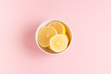 Lemon slices in a bowl top view on bright baackground