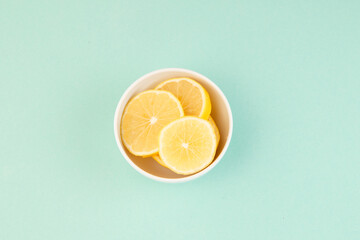 Lemon slices in a bowl top view on bright baackground