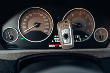 Car ignition key at the dashboard panel - obrazy, fototapety, plakaty