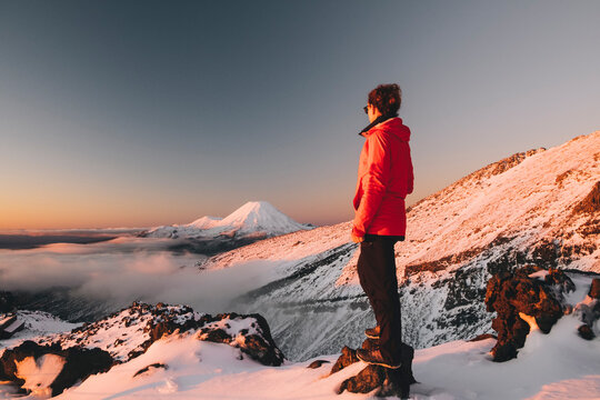 Young woman on red jacket watching Mt Ngauruhoe, Tongariro National Park, New Zealand