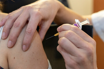 a caregiver is about to vaccinate a patient