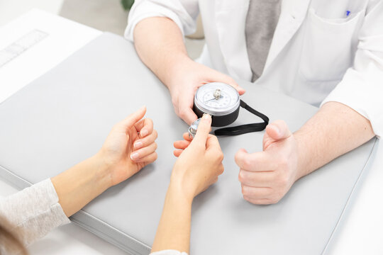 an orthopedist assesses the strength of the fingers of one hand