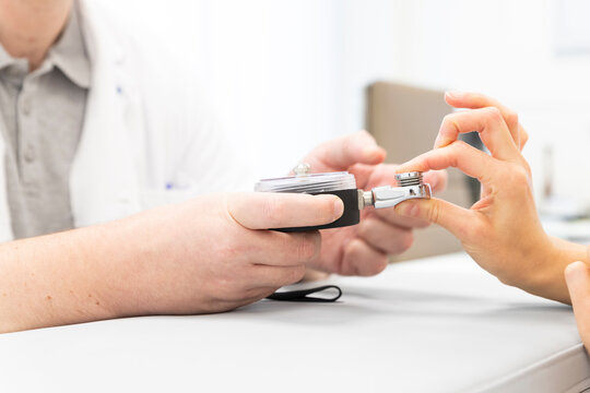 an orthopedist assesses the strength of the fingers of one hand