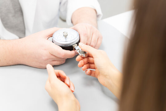 an orthopedist assesses the strength of the fingers of one hand